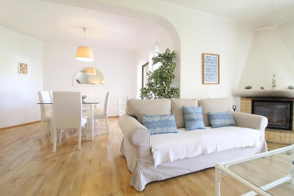 a living room with a white couch and a table at E&M Garden View Beach House VII in Porches