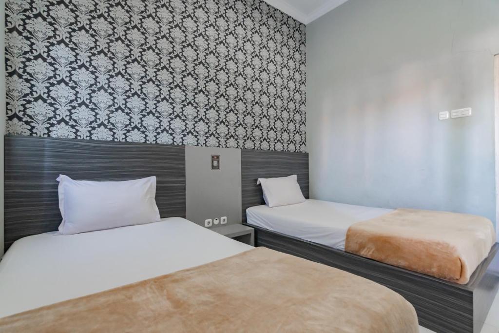 Postel nebo postele na pokoji v ubytování Hotel Markoni Pamanukan Mitra RedDoorz