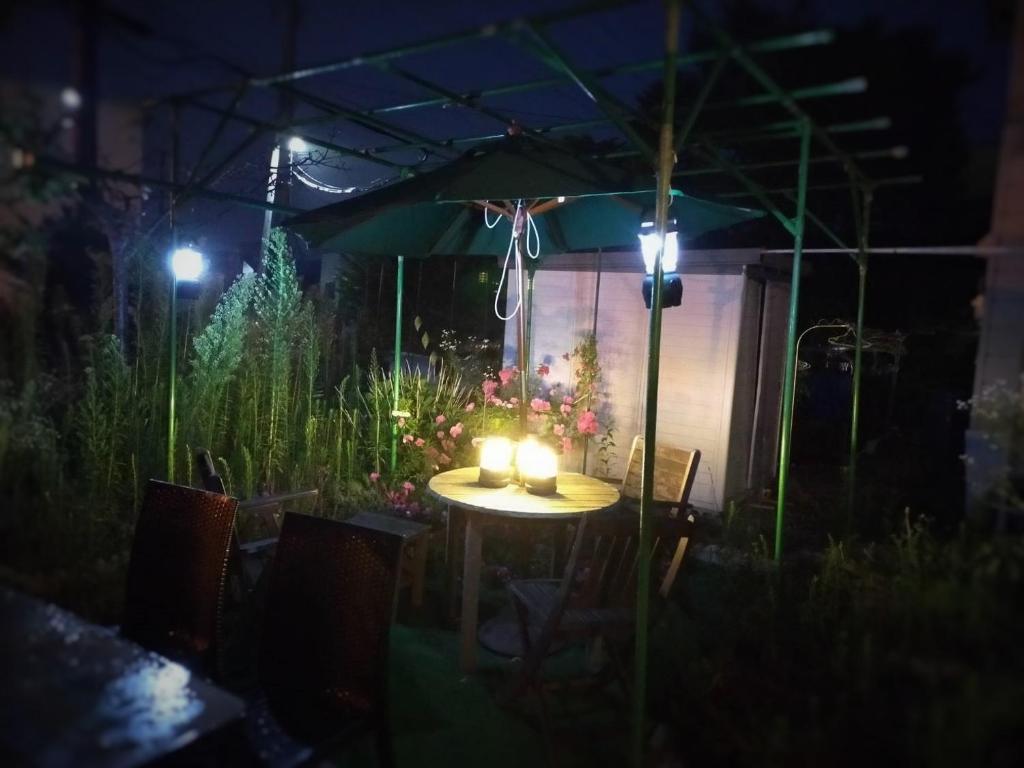 einen Tisch mit Kerzen darauf in einem Garten in der Nacht in der Unterkunft LY INN CHITOSEAIPORT - Vacation STAY 94792 in Chitose