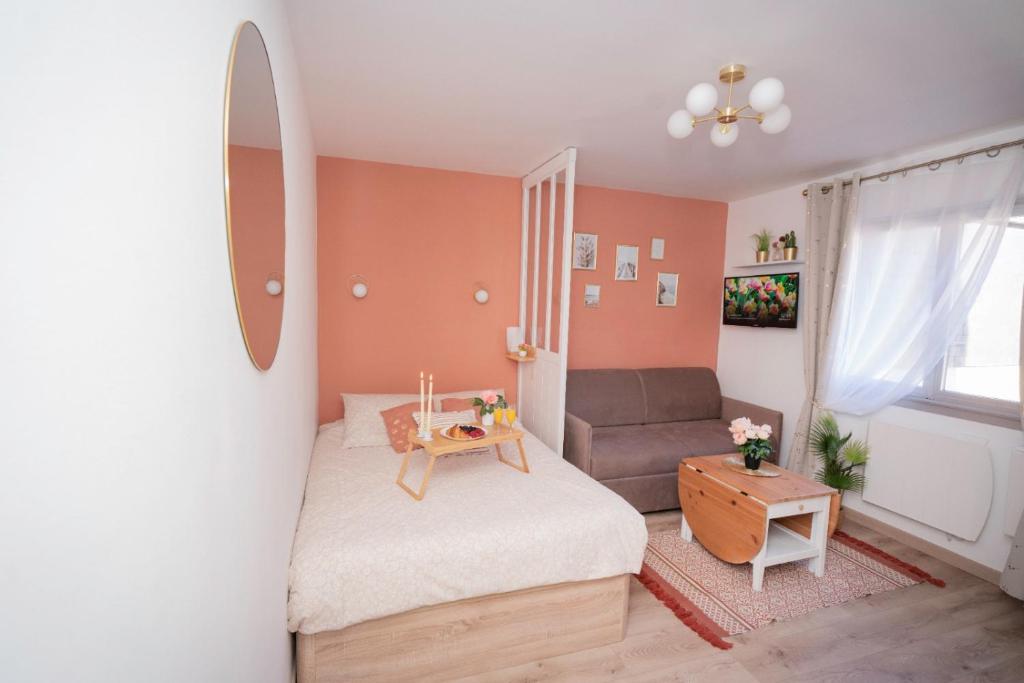 een kleine slaapkamer met een bed en een bank bij Petit Quai - Studio entièrement rénové plein centre Trouville in Trouville-sur-Mer