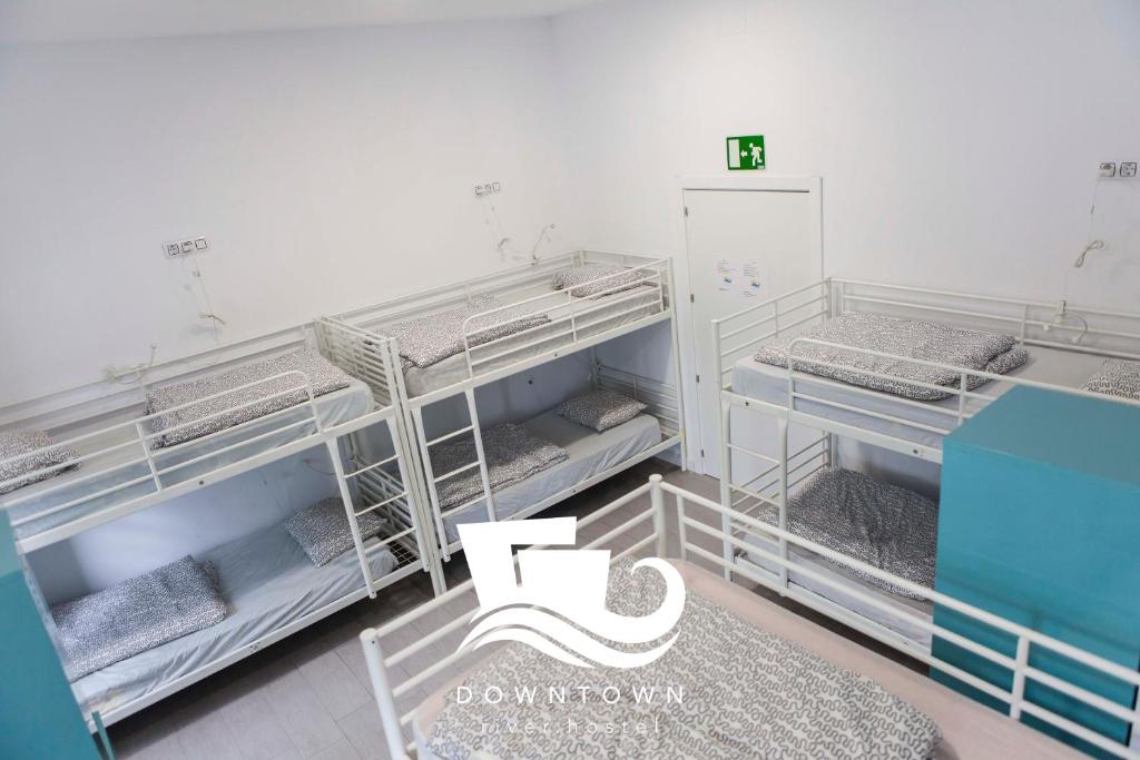 a room with three bunk beds in it at Downtown River Hostel in San Sebastián