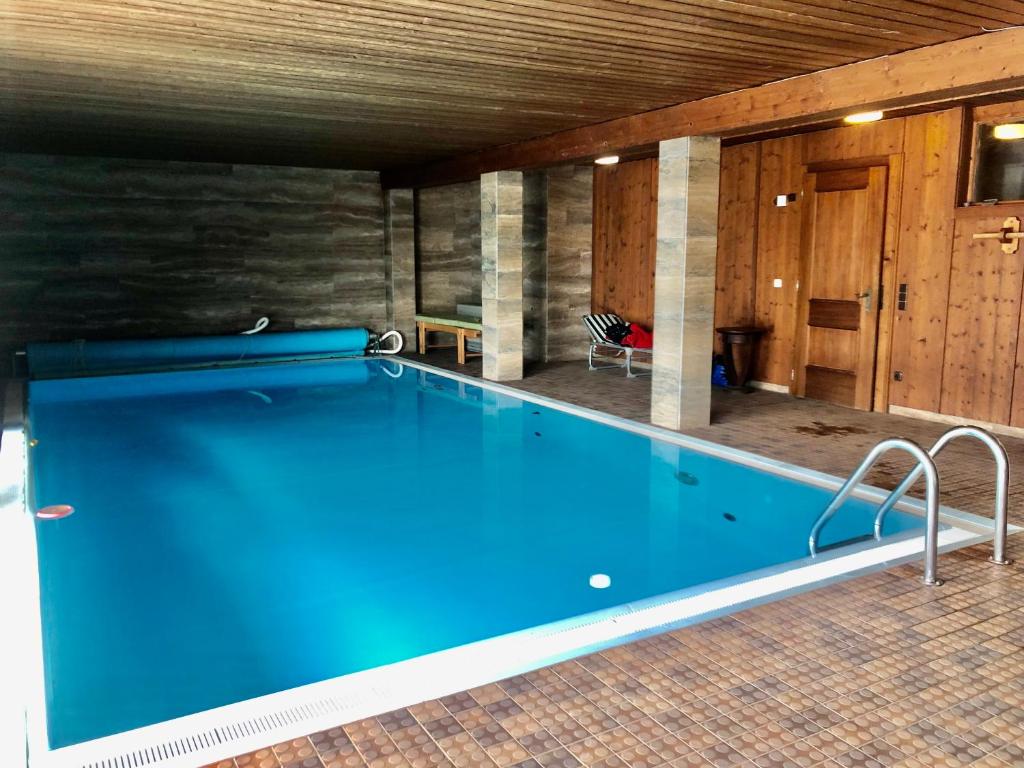 a large swimming pool in a room with at Haus Wenger Mountain View & Swimming Pool in Kaprun