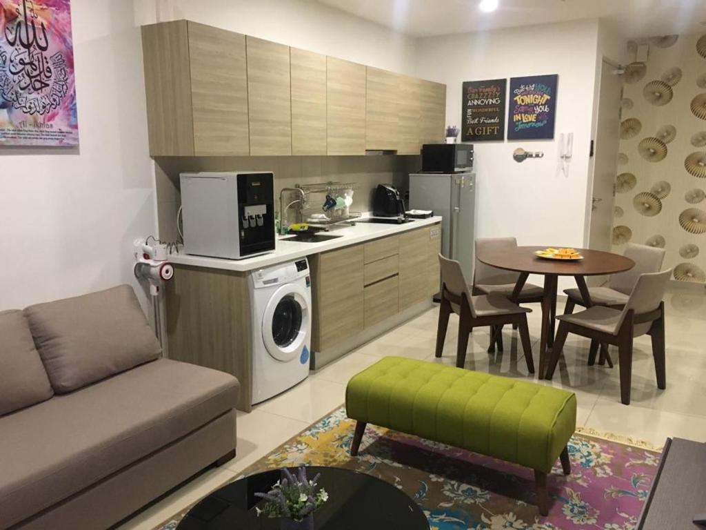 i-Suite, i-City by Mohas Homes في شاه عالم: مطبخ وغرفة معيشة مع أريكة وطاولة