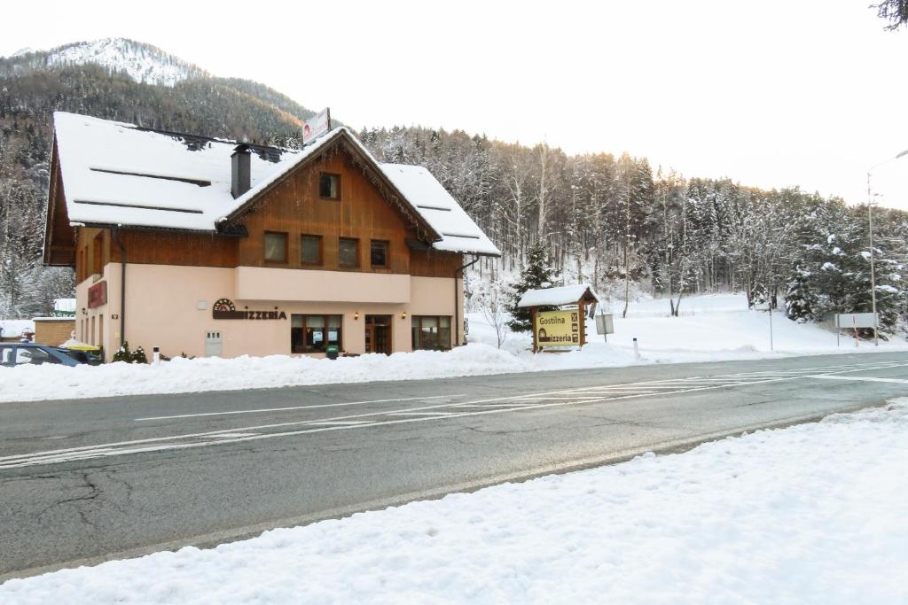 um edifício ao lado de uma estrada coberta de neve em Apartment and rooms Maraton em Kranjska Gora