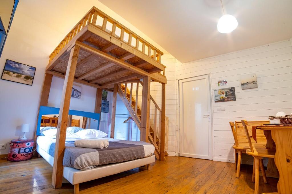 een slaapkamer met een houten bed en een houten tafel bij Étape Gimontoise 32 in Gimont