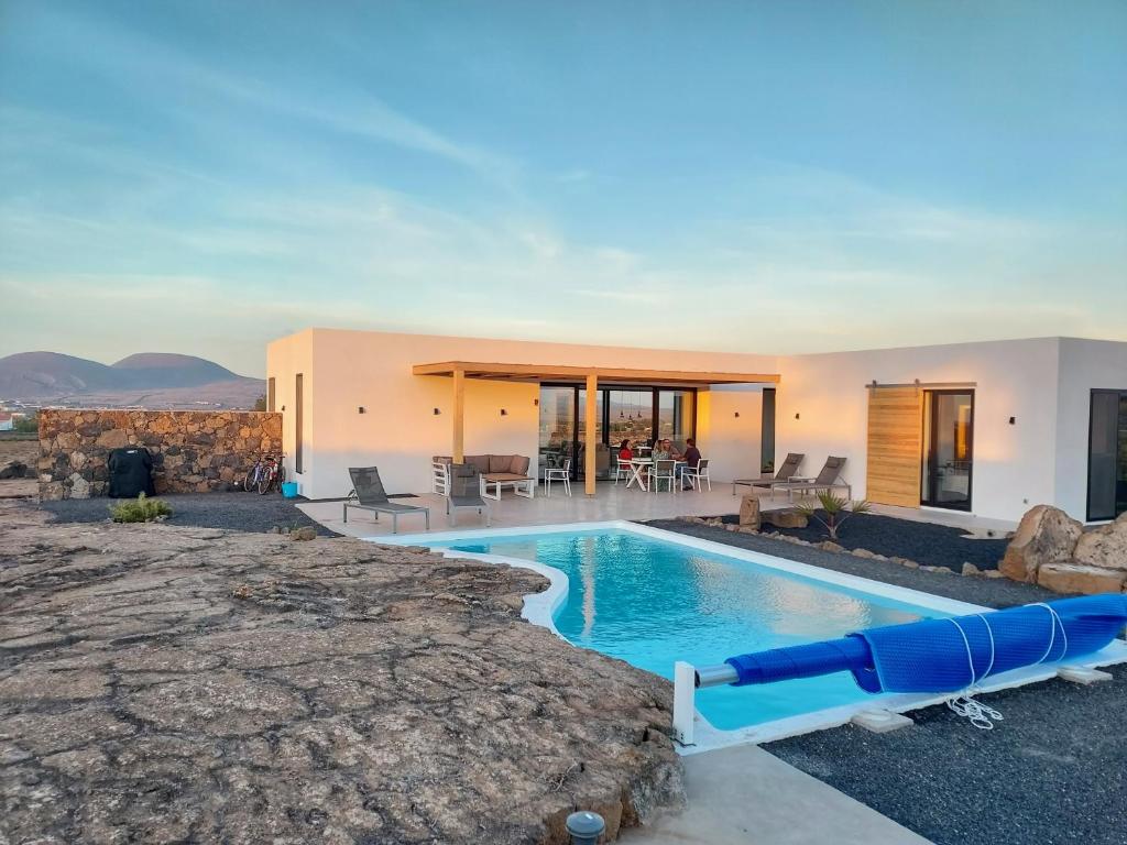 einem Pool mit Wasserrutsche vor einem Haus in der Unterkunft Villa Tabaiba en Lajares con Piscina in Lajares