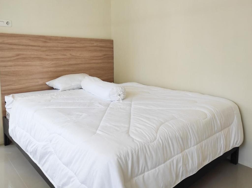 ein weißes Bett mit zwei Kissen darüber in der Unterkunft RedDoorz Syariah at Karema Area Mamuju in Karema