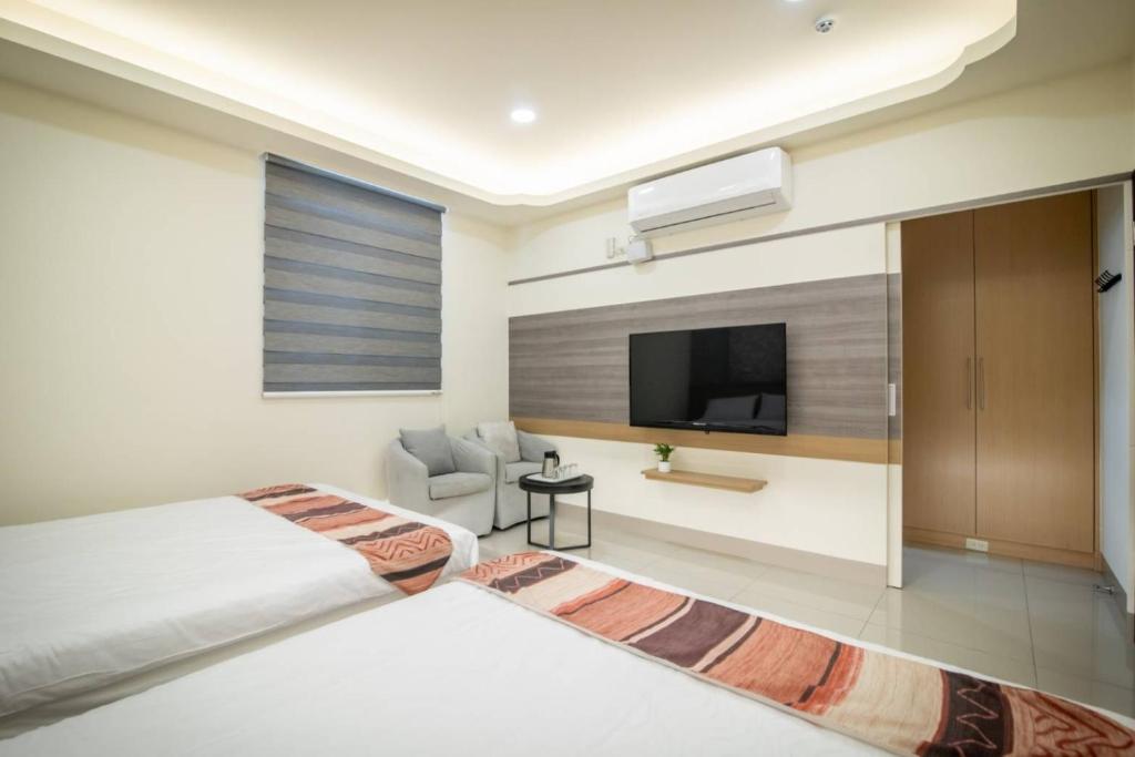 sypialnia z łóżkiem i telewizorem z płaskim ekranem w obiekcie Jialai Homestay w mieście Magong