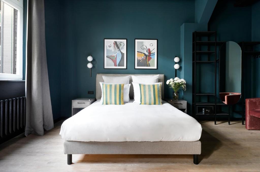 numa l Sketch Rooms & Apartments في برلين: غرفة نوم بجدران زرقاء وسرير مع الوسائد