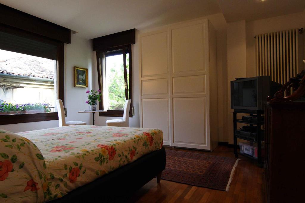 sypialnia z łóżkiem, telewizorem i oknem w obiekcie B&B Al Duomo w Padwie