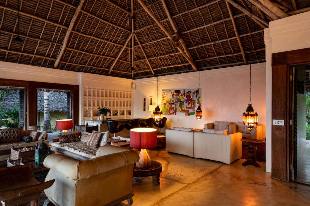 a living room with couches and chairs and a ceiling at Qambani Luxury Resort in Michamvi
