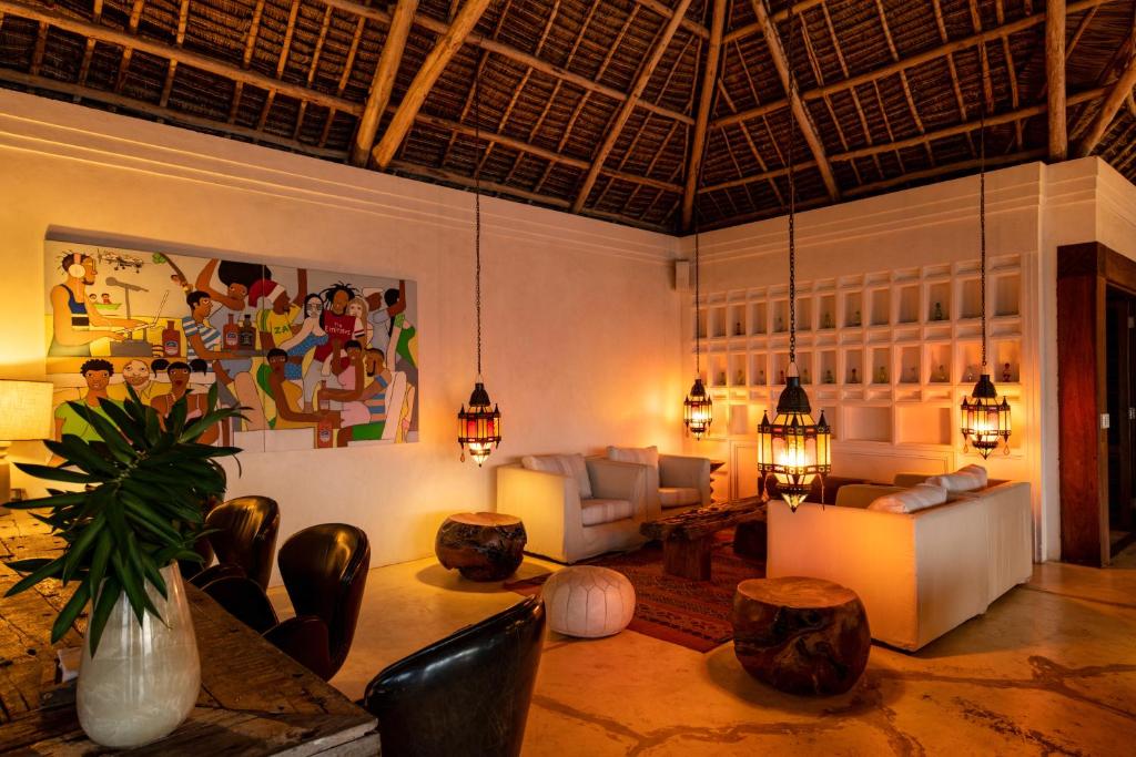 a living room with couches and a table and chairs at Qambani Luxury Resort in Michamvi