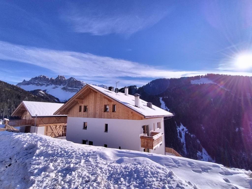 uma casa no topo de uma montanha coberta de neve em Zimmererhof em Bressanone