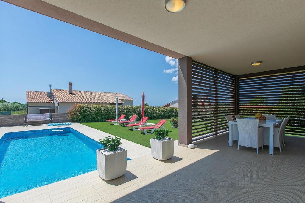 patio z basenem, stołem i krzesłami w obiekcie Villa Štefanja w mieście Galižana