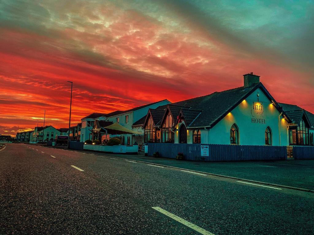a building on the side of a street with a sunset at Inn On The Coast in Portrush