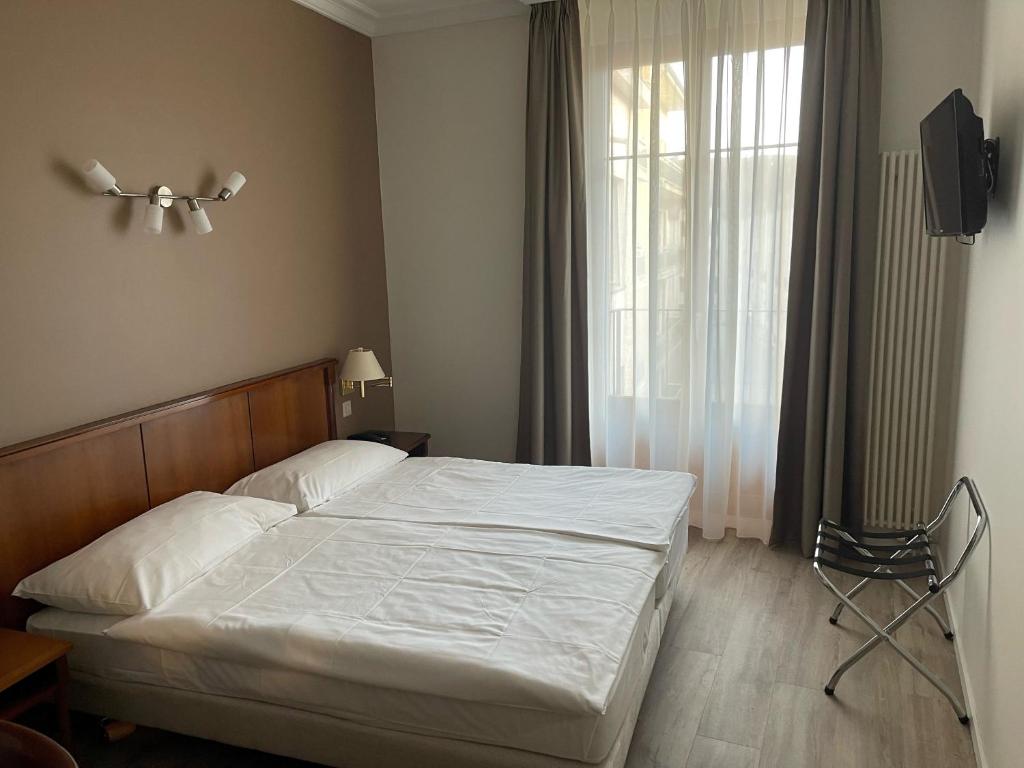 Ein Bett oder Betten in einem Zimmer der Unterkunft Hôtel des Alpes