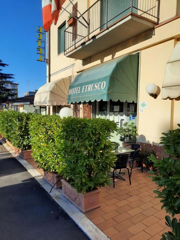 un ristorante con tavolo e ombrellone verde di Hotel Etrusco a Sesto Fiorentino