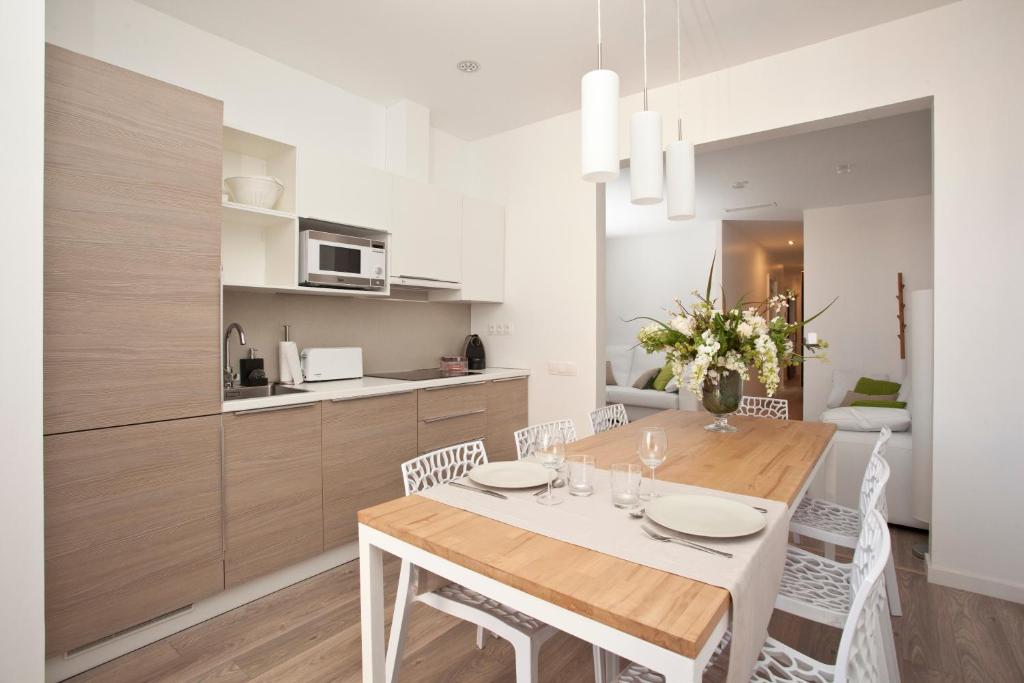 a kitchen and dining room with a table and chairs at Decô Apartments Barcelona-Eixample in Barcelona