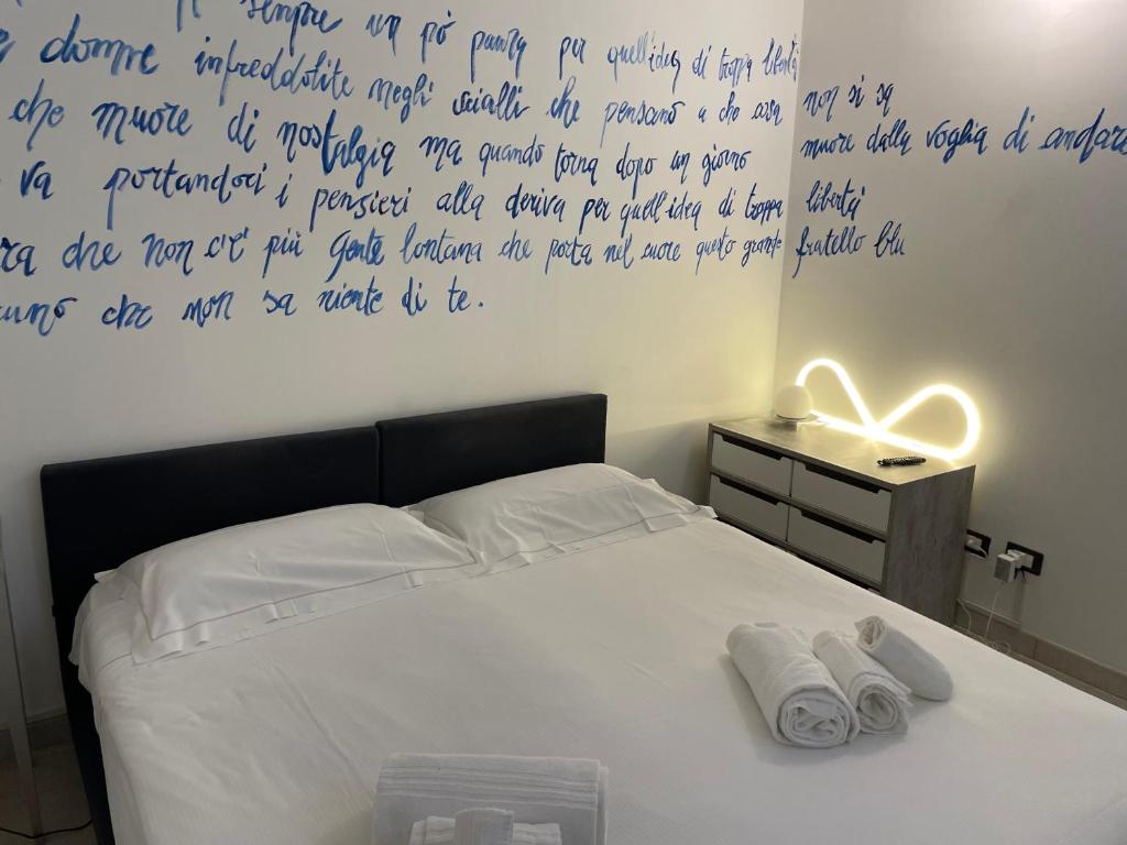 a bedroom with a bed with writing on the wall at Splendida taverna dotata di tutti i comfort a 500 mt dal mare in Marina di Carrara