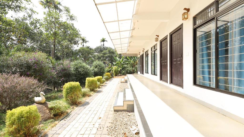 an empty porch of a house with benches and plants at Vibgyor Villa in Munnar