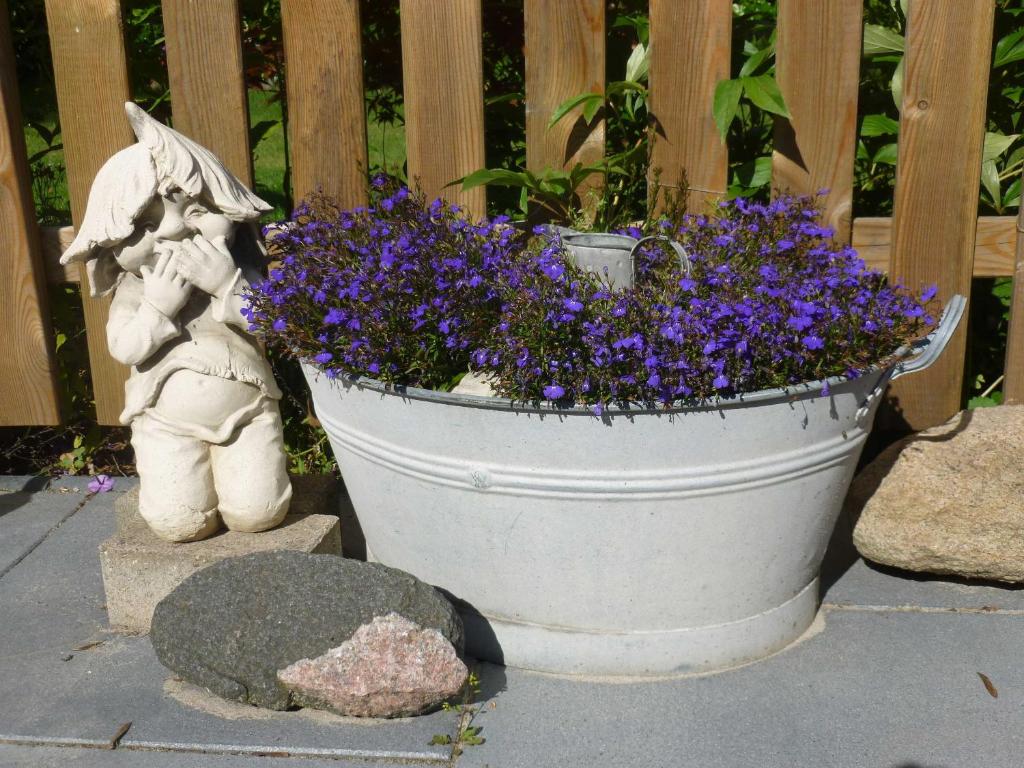 a planter with purple flowers in it next to a fence at FeWo Ostseestrand in Neustadt in Holstein