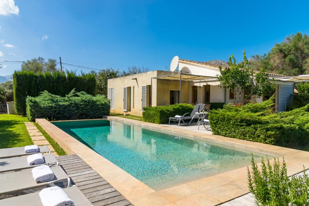 a swimming pool in front of a house at Villa Cal Padri By SunVillas Mallorca in Pollença