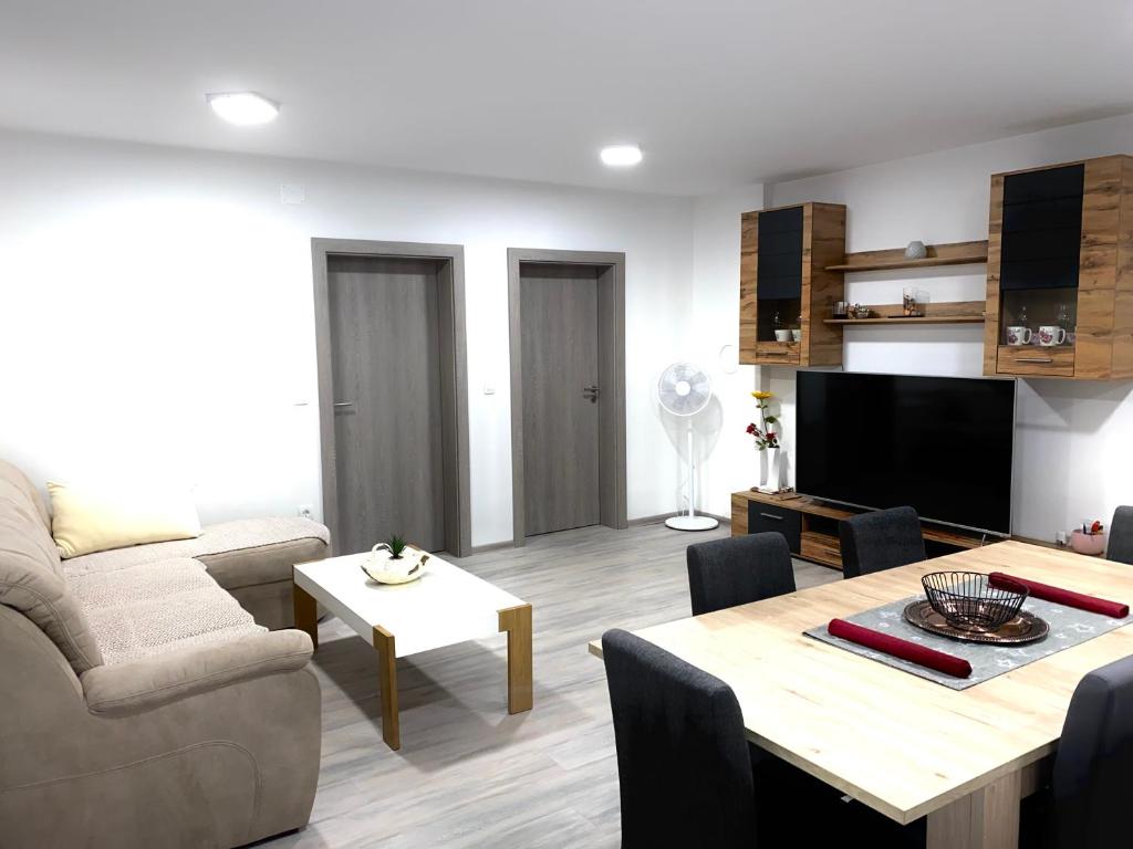 ein Wohnzimmer mit einem Sofa und einem Tisch in der Unterkunft Perfect Place apartment in Kranj