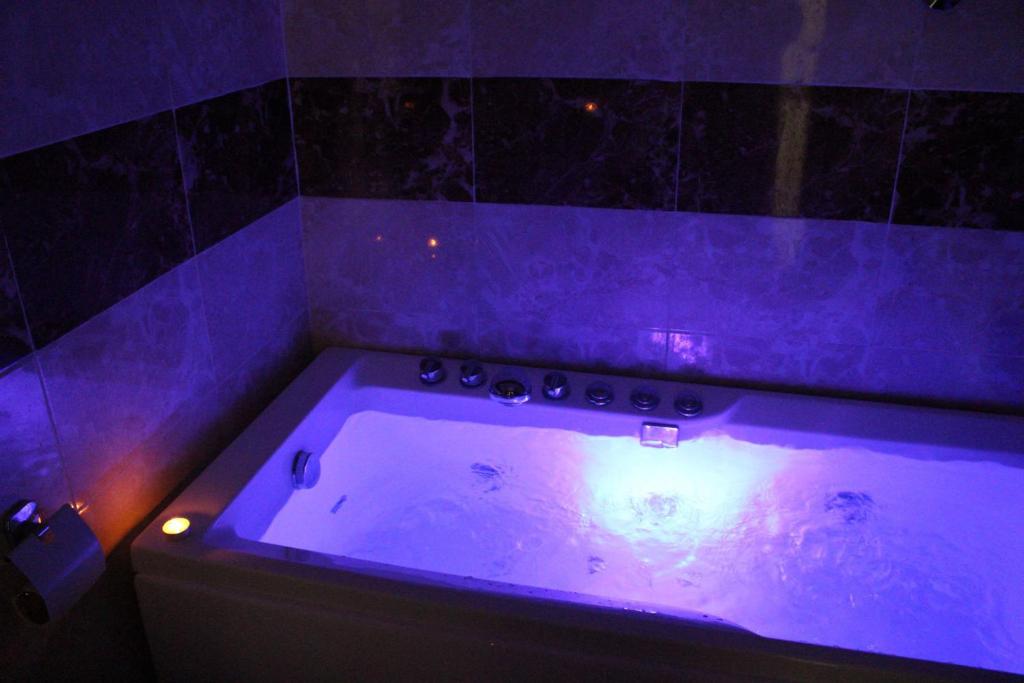 a purple bath tub in a room with a toilet at Al Rafahya Crown in Riyadh