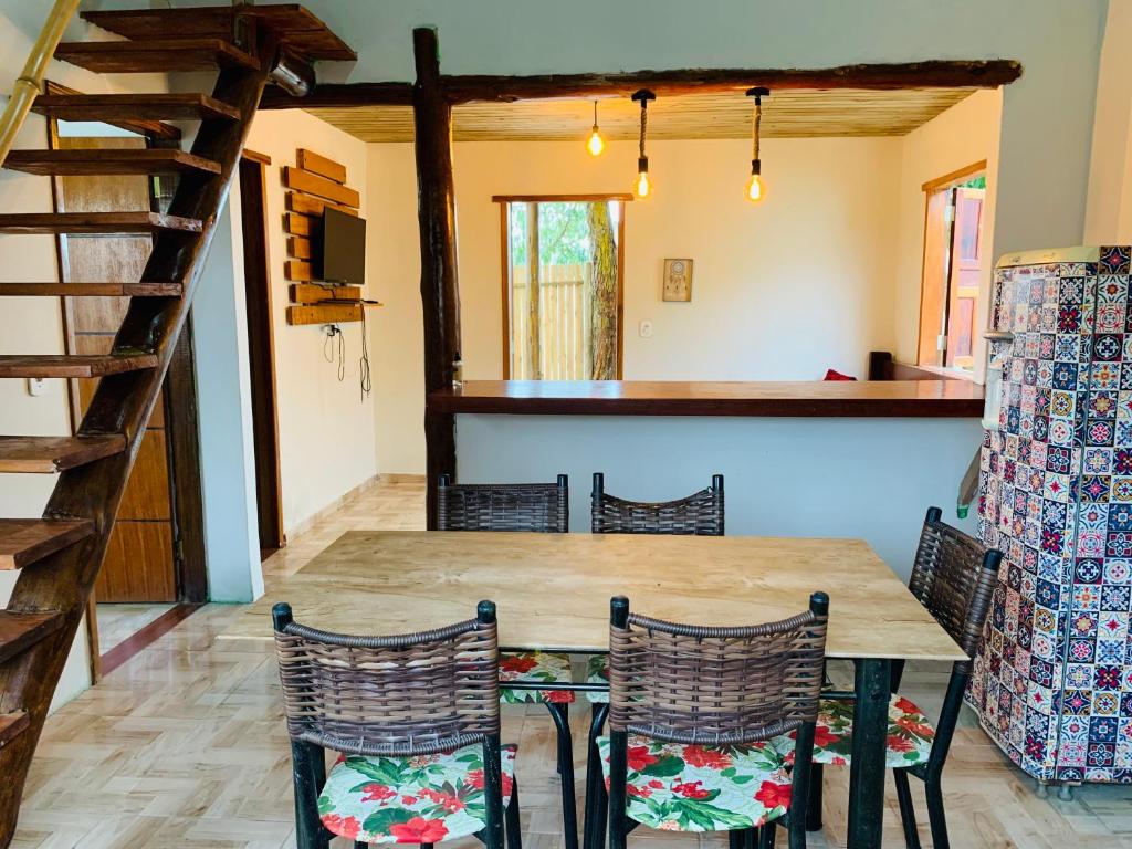 Un comedor con mesa y sillas de madera. en Casa do sol, en Caraíva