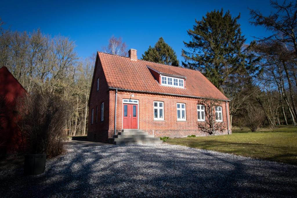 una casa de ladrillo rojo con puerta roja en Visborggaard Slots Parkhus, en Hadsund