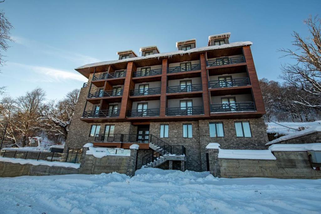 un edificio con nieve delante en Genesis Bakuriani, en Bakuriani