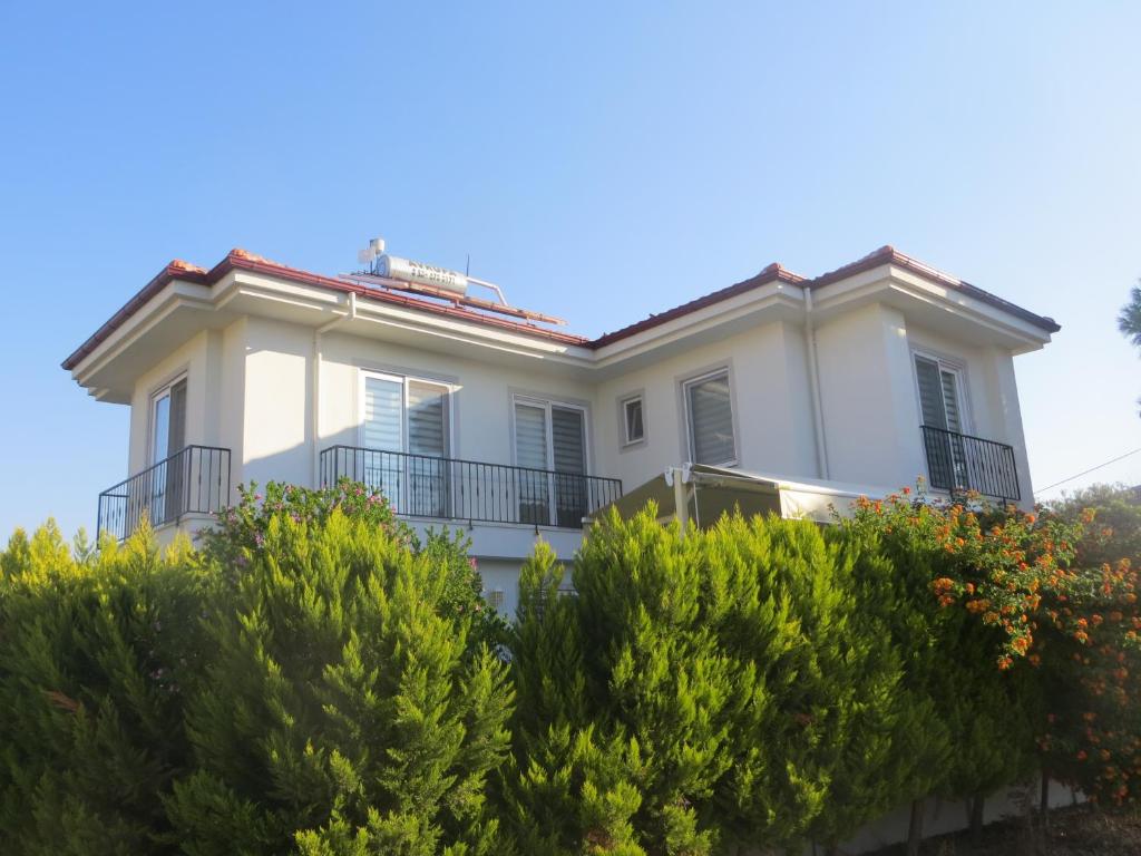 a white house with bushes in front of it at VillaSevval - Stunning 4-Bed Villa in Dalyan
