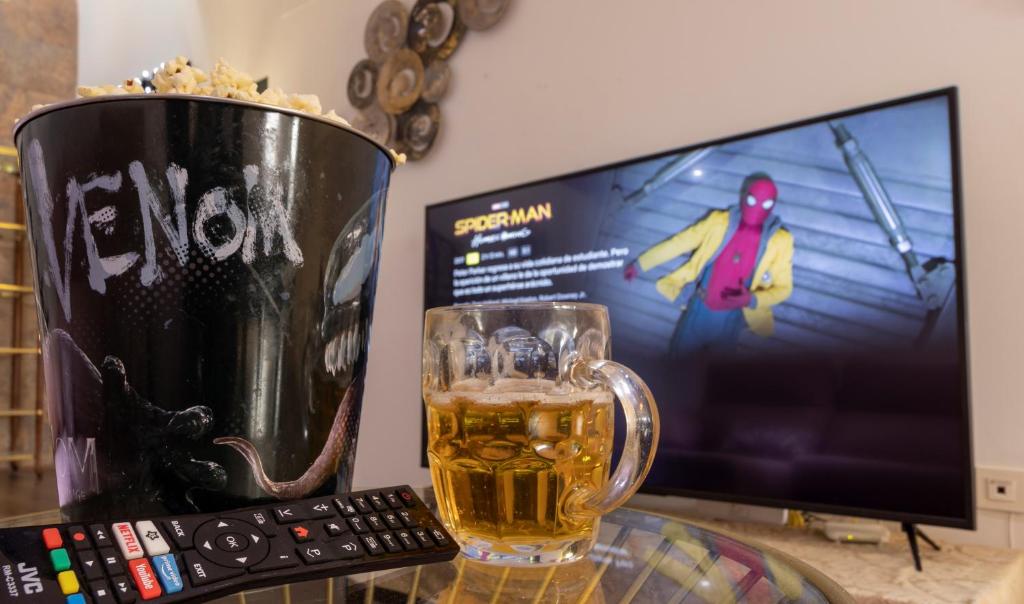 een glas bier naast een tv bij Comfort Center in Almería