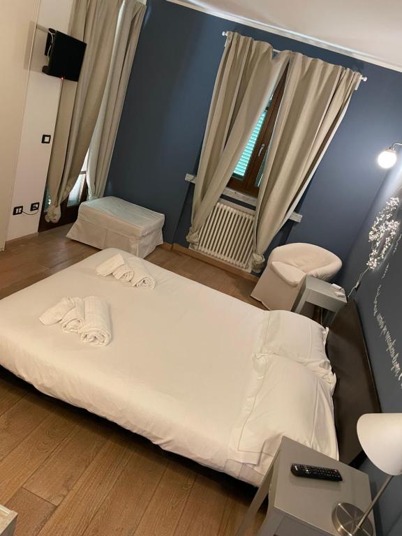 una camera da letto con un grande letto bianco e una finestra di Elegante camera matrimoniale con balcone a 500 mt dal mare a Marina di Carrara