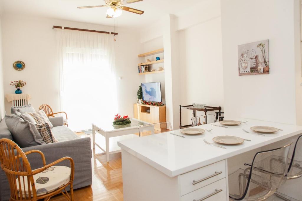 a kitchen with a white island in a living room at Cozy apt with Lycabettus View! in Athens
