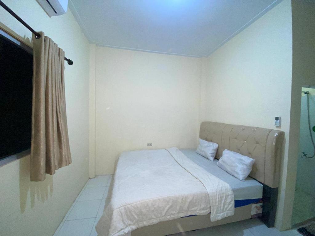 a small bedroom with a bed in a room at Pondok Indah Syariah near Suzuya Mall Langsa RedPartner in Birimpontong