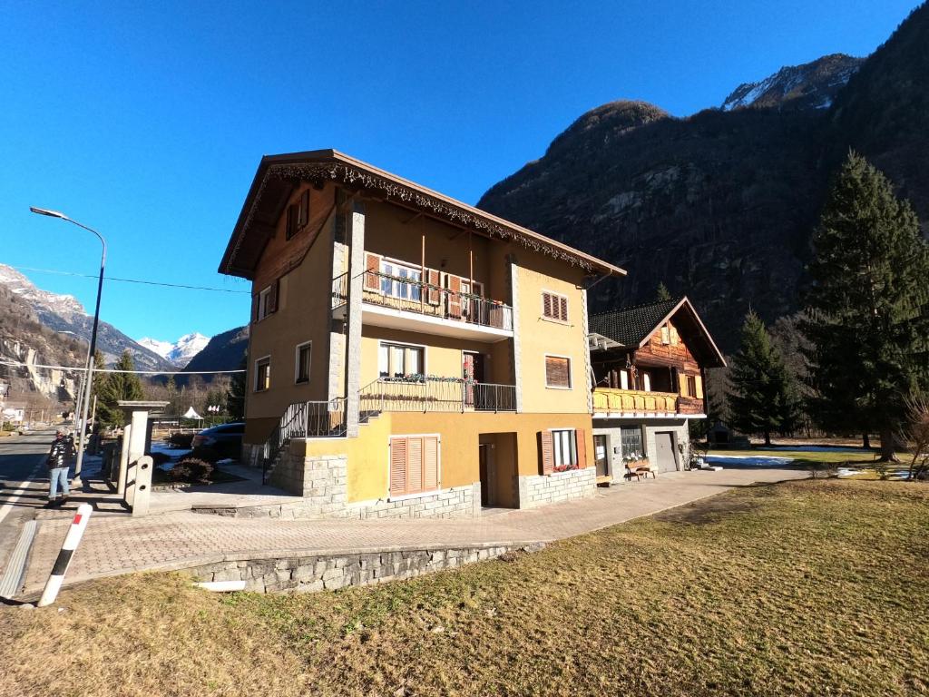 a building with a balcony and mountains in the background at Baggio House in Cadarese