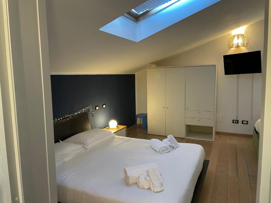 een slaapkamer met een bed met twee handdoeken erop bij Splendida camera familiare con lucernario a 500 mt dal mare in Marina di Carrara