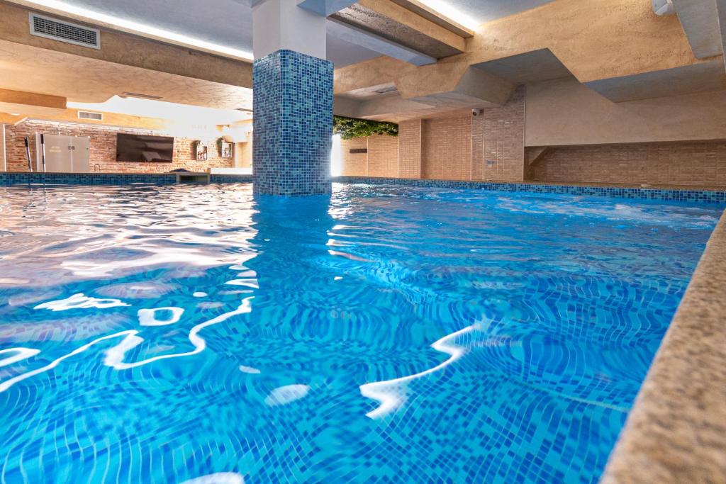 una piscina en un hotel con agua azul en Баня Аква Ризорт, en Banya