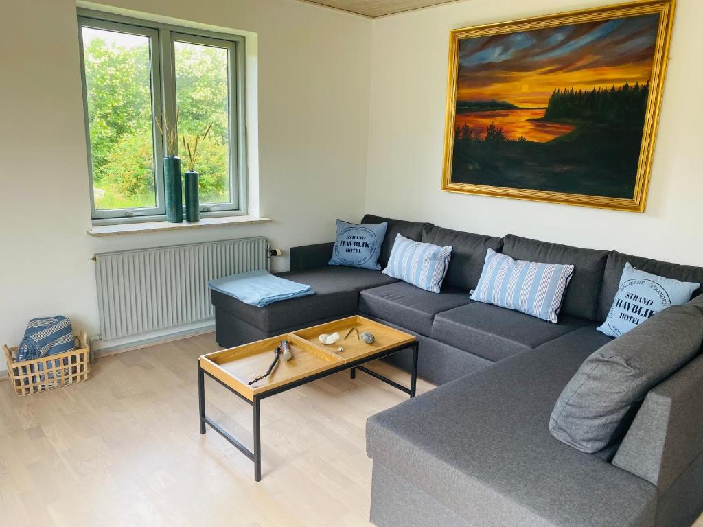 uma sala de estar com um sofá e uma mesa em Beautiful villa close to beach and nature em Hanstholm
