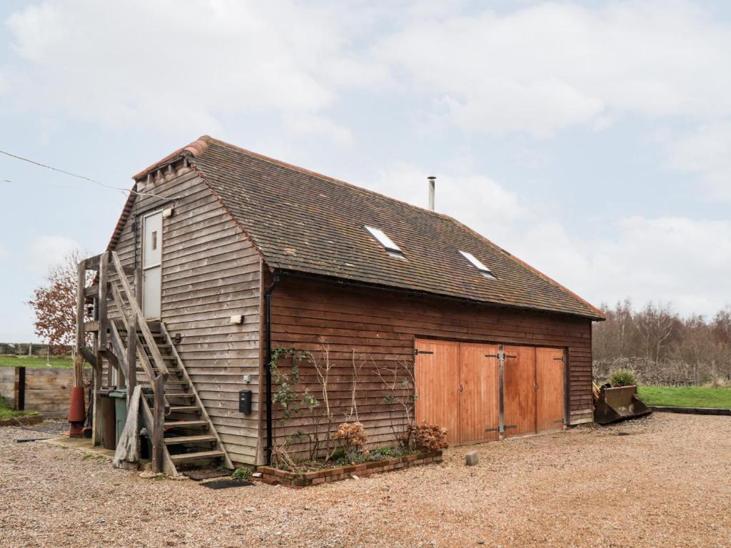 an old barn with a ladder on the side of it at Egypt Granary in Tonbridge