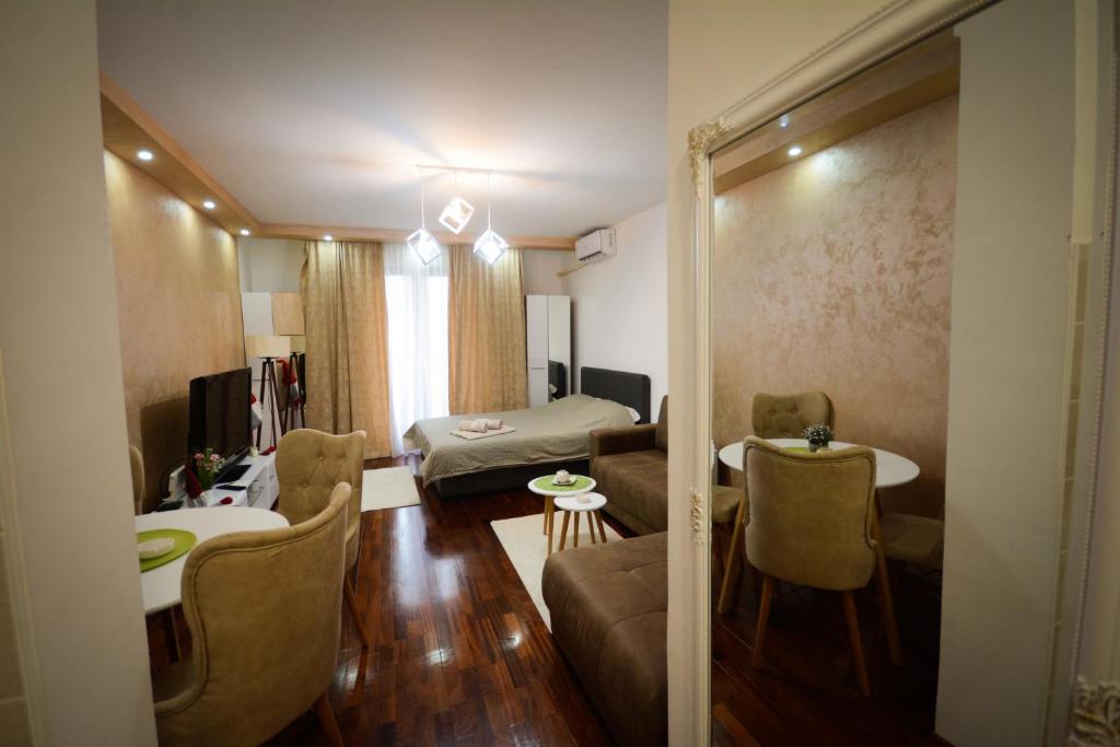 - un salon avec un canapé et un lit dans l'établissement Apartman In Lux, à Vrnjačka Banja
