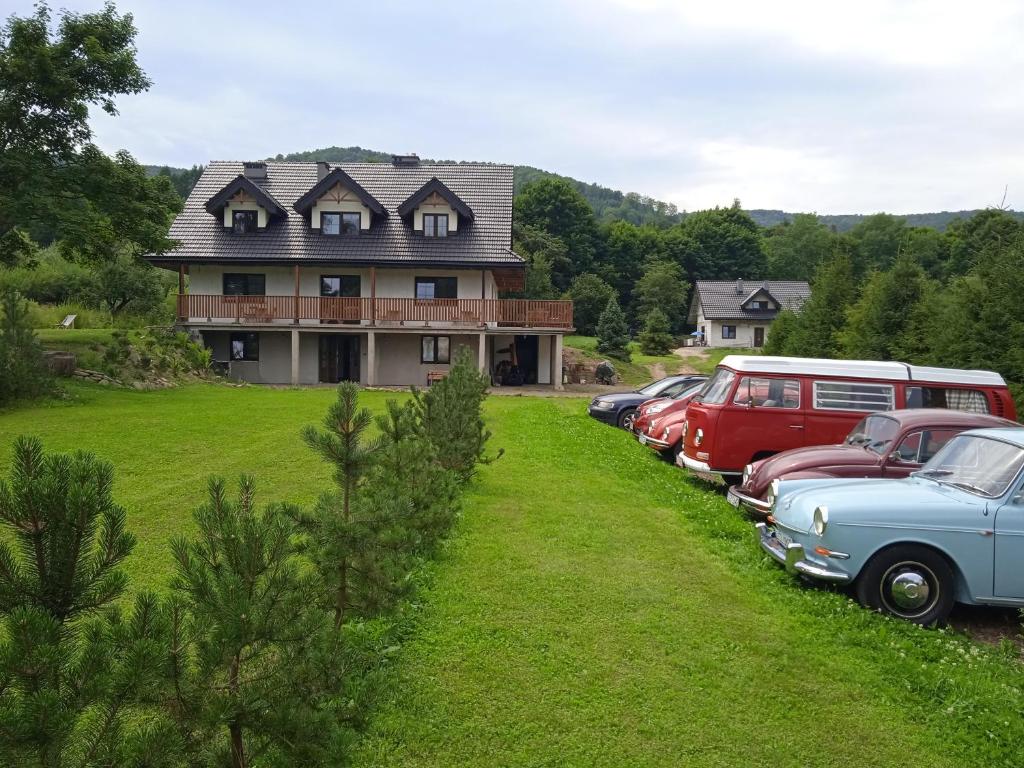 a row of cars parked in front of a house at Powidok in Wetlina