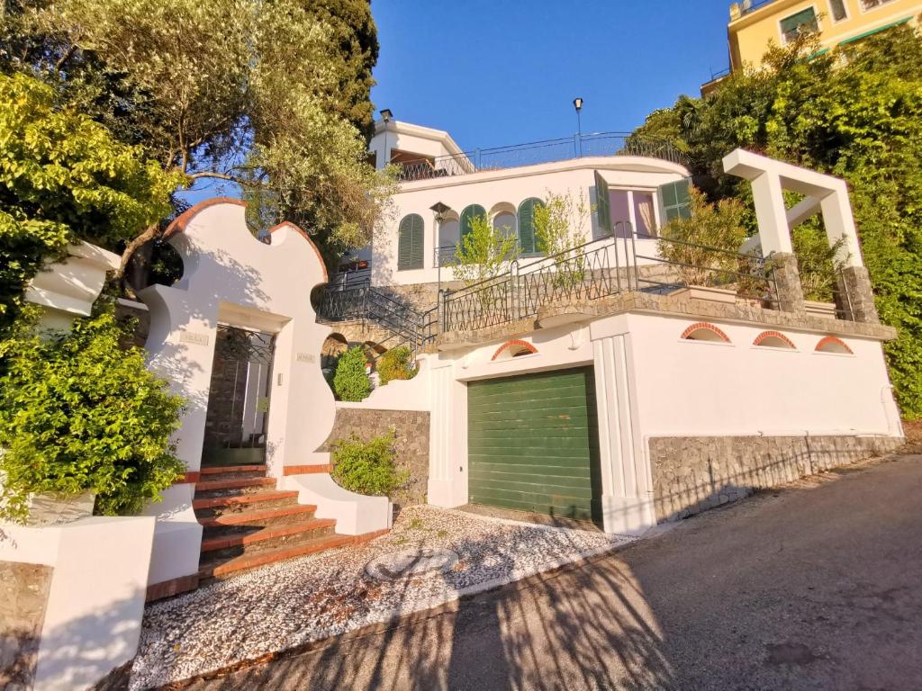 ein weißes Haus mit einem Tor und einer Garage in der Unterkunft Rapallo Summer House in Rapallo