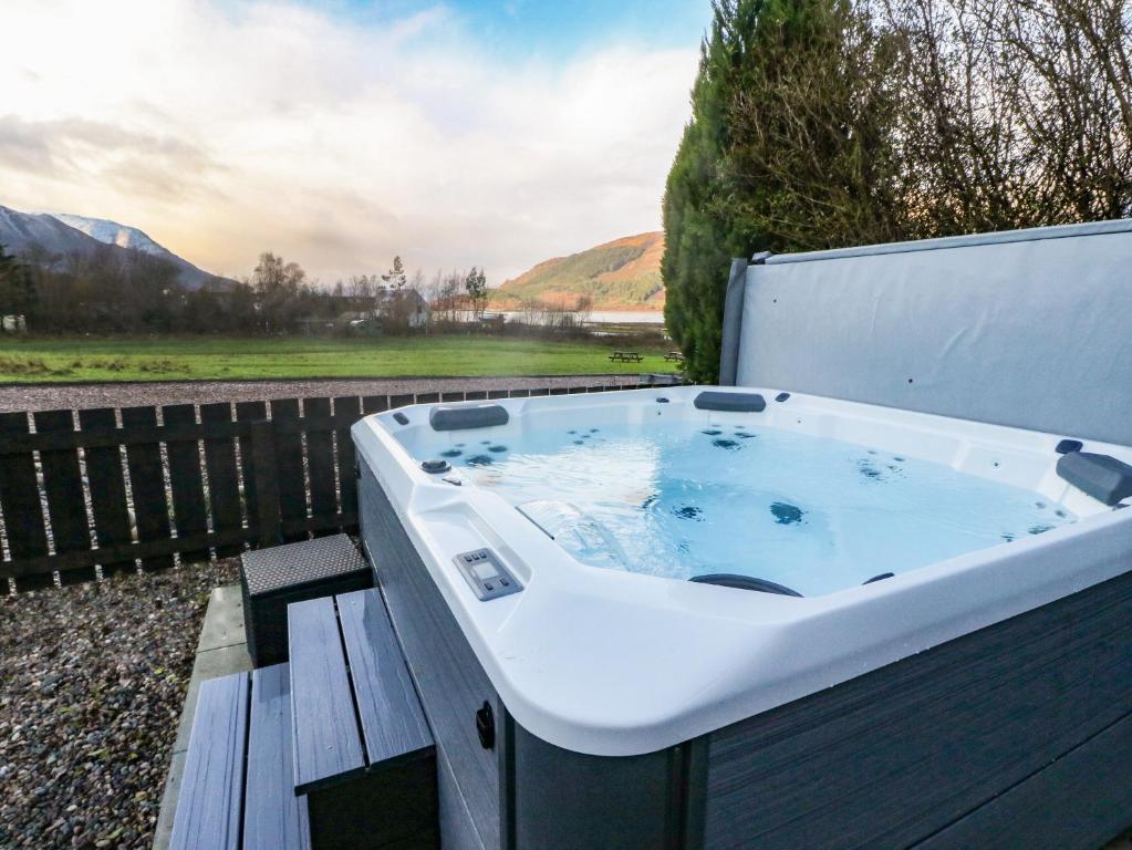 a large bath tub sitting on a wooden bench at Island View House in Ballachulish