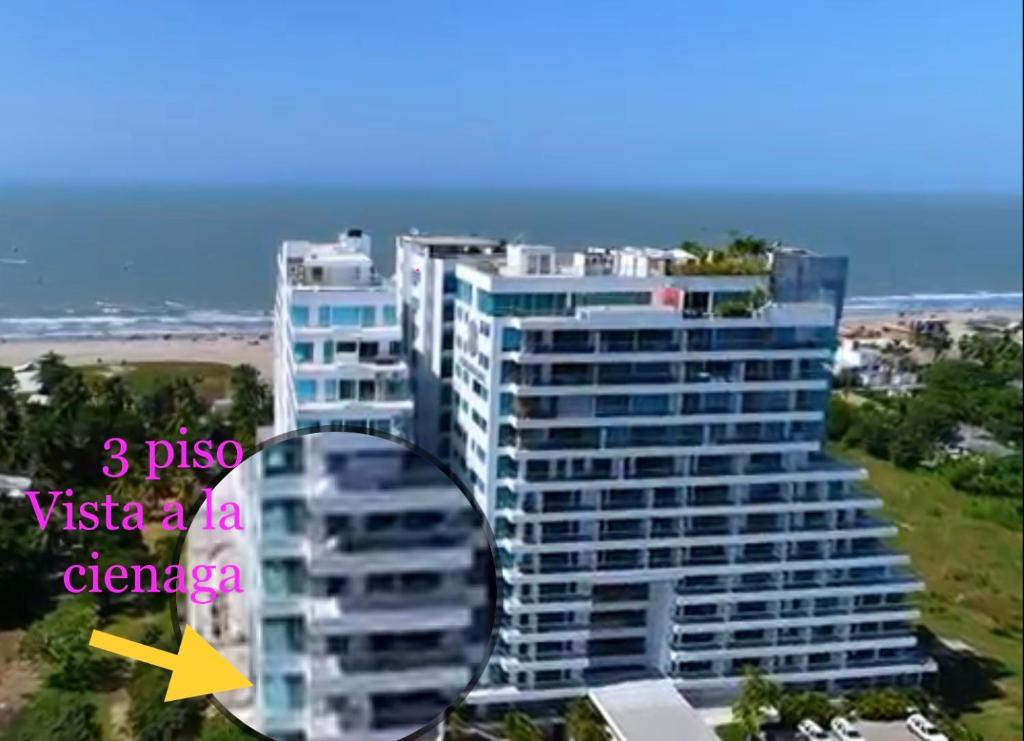 Playa la Boquilla, Apto dentro Condominio Hotel Sonesta في كارتاهينا دي اندياس: عمارة سكنية طويلة عليها سهم اصفر