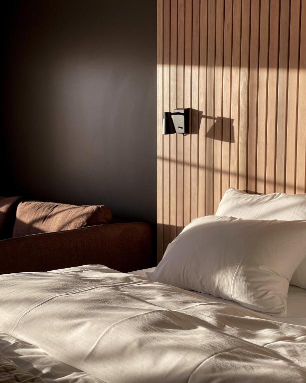 una camera da letto con un letto bianco con testiera in legno di Hovdestøylen a Hovden