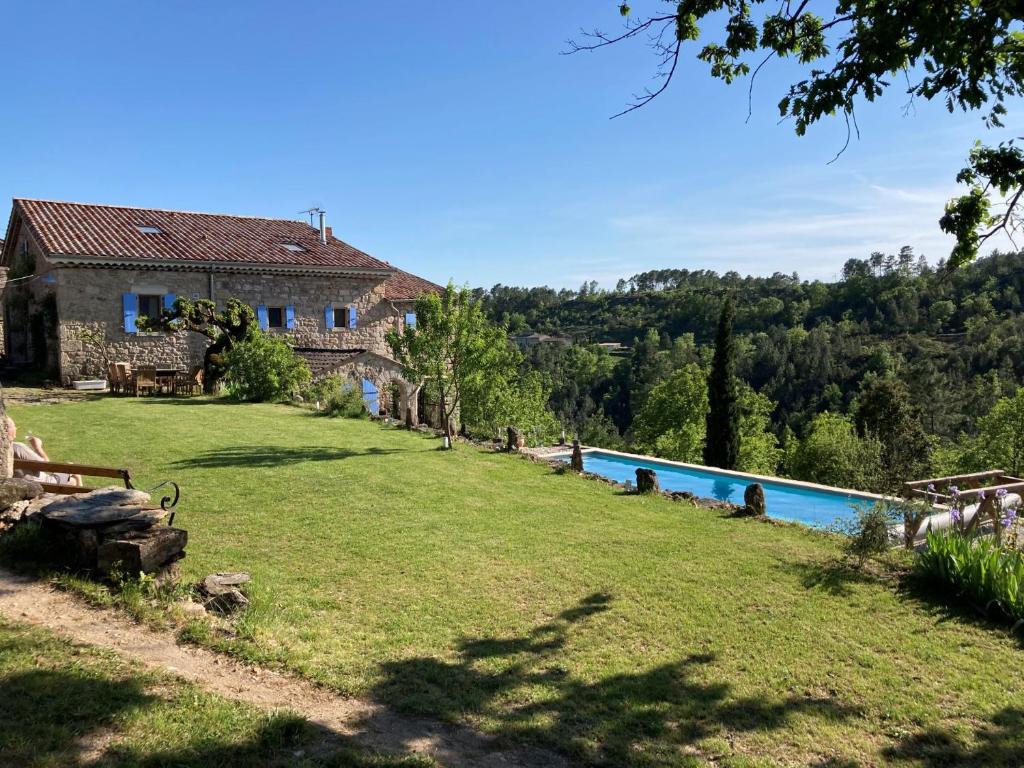 an external view of a house and a swimming pool at Mas de la Giralde in Payzac