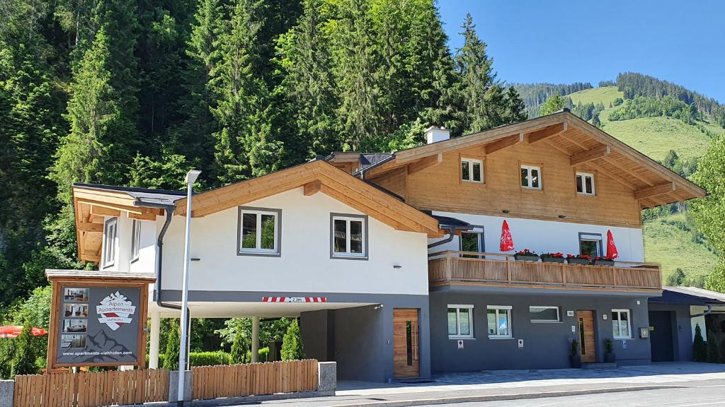 a large house with a wooden roof at Alpen Appartements Viehhofen in Viehhofen