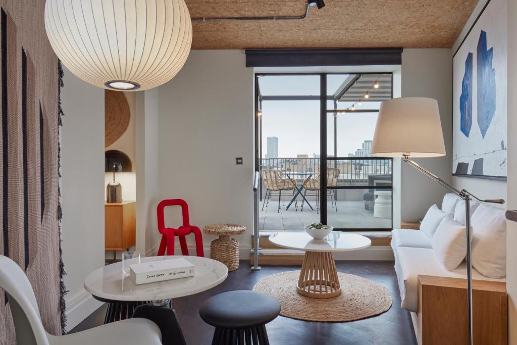 a living room with a couch and a table at One Hundred Shoreditch in London